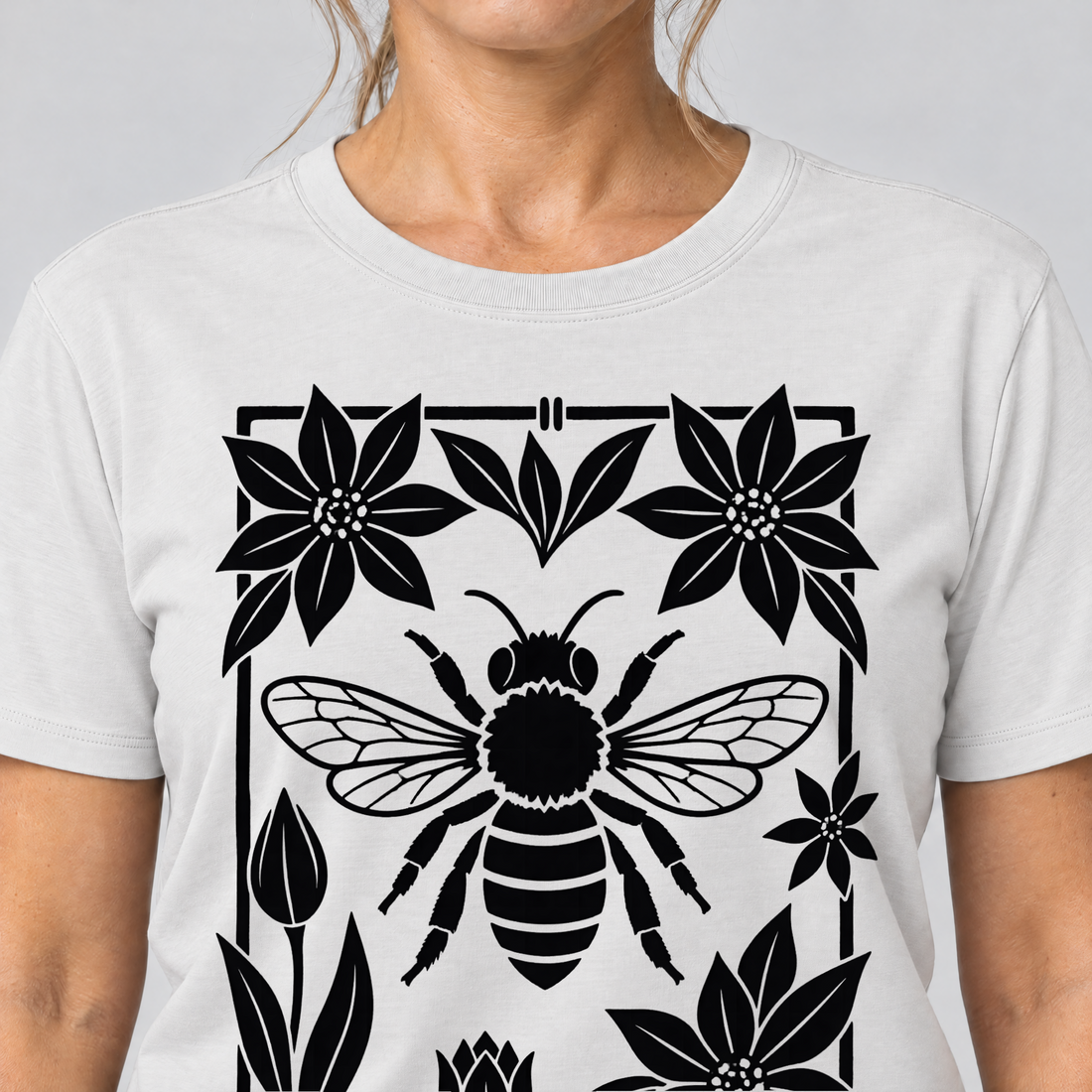 Nahaufnahme des Drucks: Biene im Blütenrahmen – T-Shirt Unisex in Weiß, von einer Frau getragen