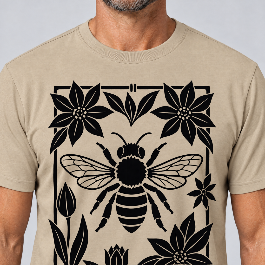 Nahaufnahme des Drucks: Biene im Blütenrahmen – T-Shirt Unisex in Sand, von einem Mann getragen
