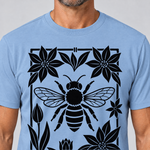 Nahaufnahme des Drucks: Biene im Blütenrahmen – T-Shirt Unisex in Himmelblau, von einem Mann getragen