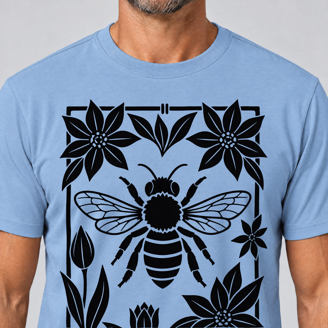 Nahaufnahme des Drucks: Biene im Blütenrahmen – T-Shirt Unisex in Himmelblau, von einem Mann getragen