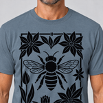 Nahaufnahme des Drucks: Biene im Blütenrahmen – T-Shirt Unisex in Steinblau, von einem Mann getragen