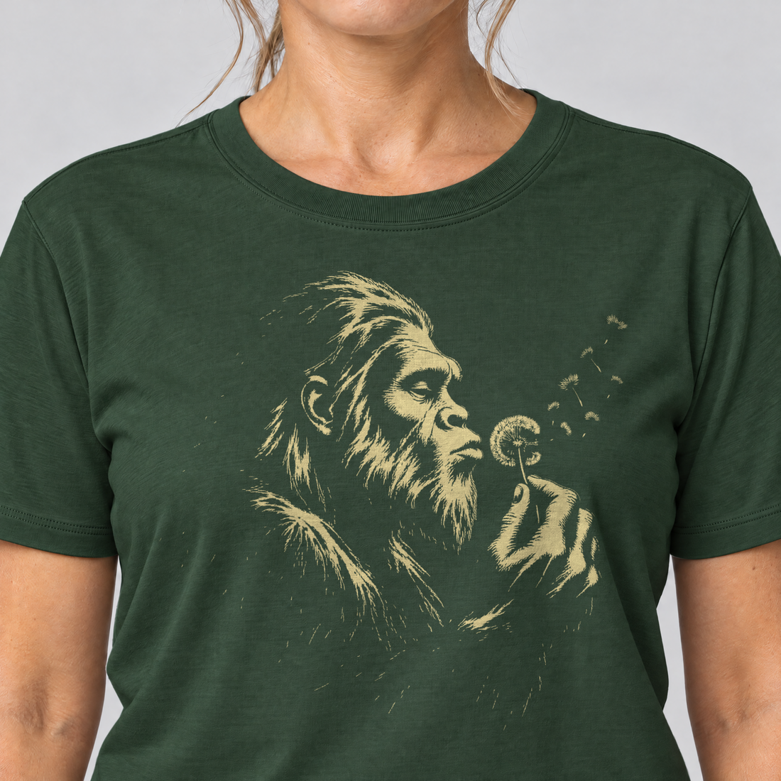 Nahaufnahme des Drucks: Bigfoot mit Pusteblume – T-Shirt Unisex in Flaschengrün, von einer Frau getragen