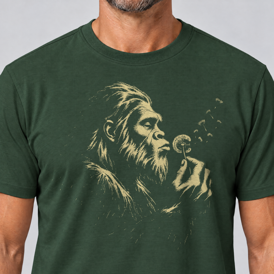 Nahaufnahme des Drucks: Bigfoot mit Pusteblume – T-Shirt Unisex in Flaschengrün, von einem Mann getragen