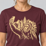 Nahaufnahme des Drucks: Bigfoot-Selfie im Bergwald – T-Shirt Unisex in Bordeaux, von einer Frau getragen