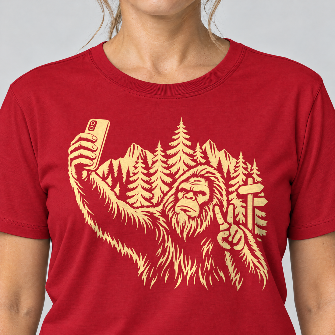 Nahaufnahme des Drucks: Bigfoot-Selfie im Bergwald – T-Shirt Unisex in Rot, von einer Frau getragen