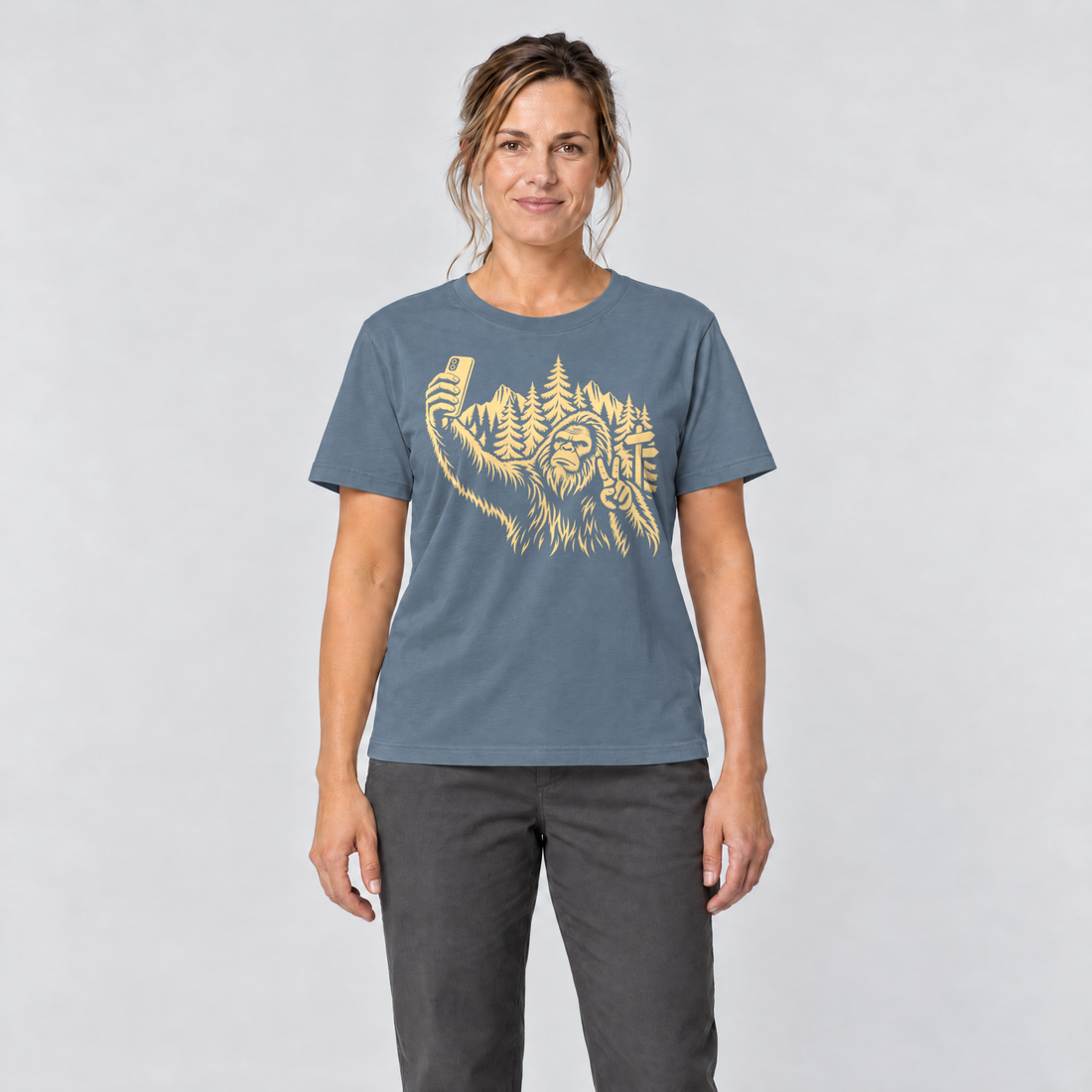 Frau trägt Bigfoot-Selfie im Bergwald – T-Shirt Unisex in Steinblau, Ansicht von vorn