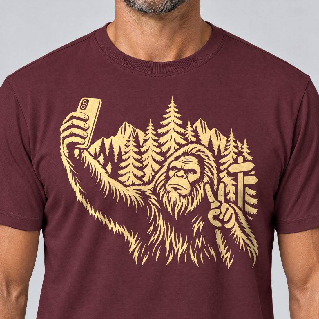 Nahaufnahme des Drucks: Bigfoot-Selfie im Bergwald – T-Shirt Unisex in Bordeaux, von einem Mann getragen