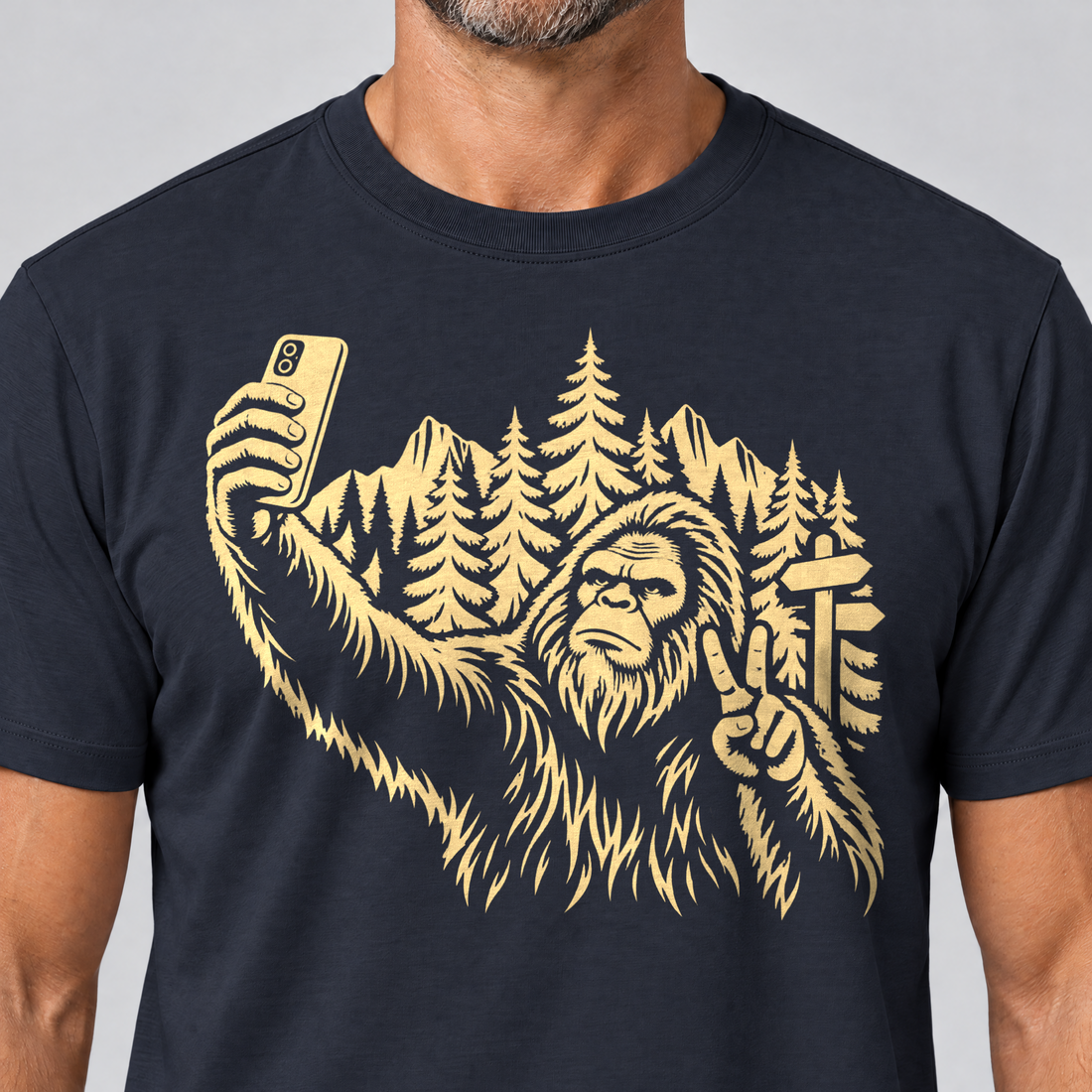Nahaufnahme des Drucks: Bigfoot-Selfie im Bergwald – T-Shirt Unisex in Navy, von einem Mann getragen