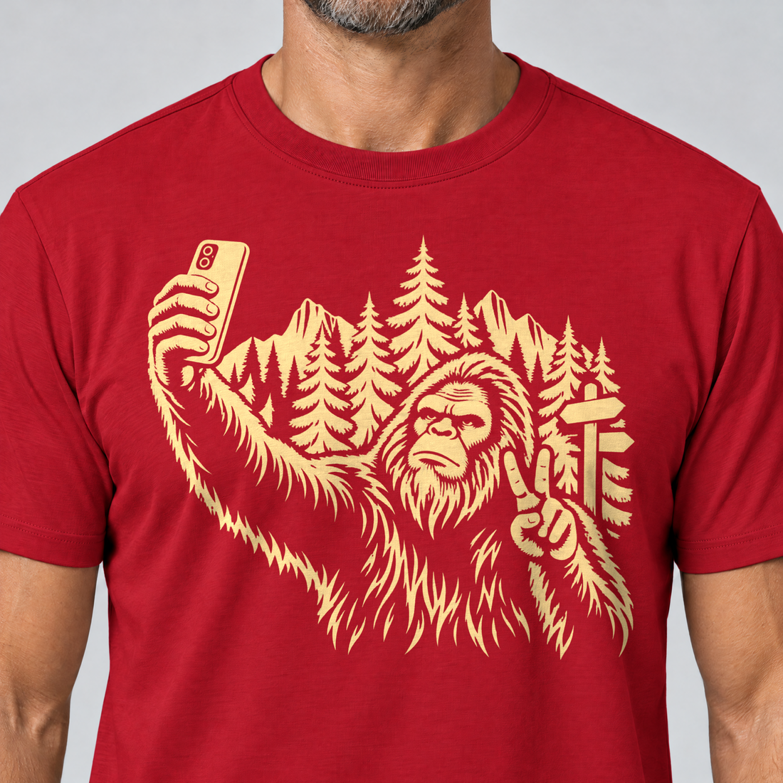 Nahaufnahme des Drucks: Bigfoot-Selfie im Bergwald – T-Shirt Unisex in Rot, von einem Mann getragen