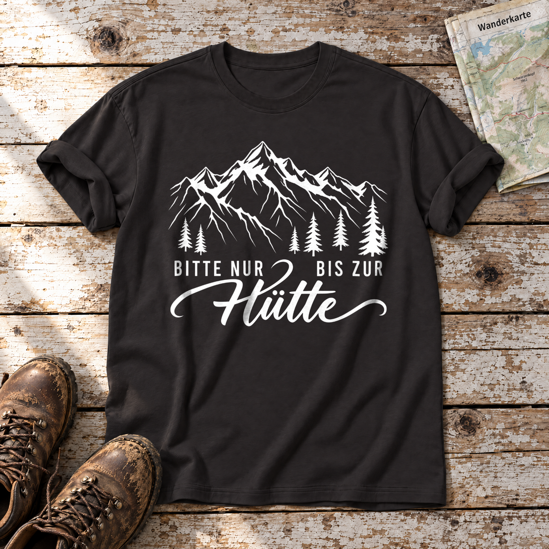 Bitte nur bis zur Hütte – T-Shirt Unisex in Schwarz, flach liegend auf alten Holzbrettern mit Wanderschuhen und Wanderkarte.