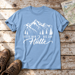 Bitte nur bis zur Hütte – T-Shirt Unisex in Himmelblau, flach liegend auf alten Holzbrettern mit Wanderschuhen und Wanderkarte.