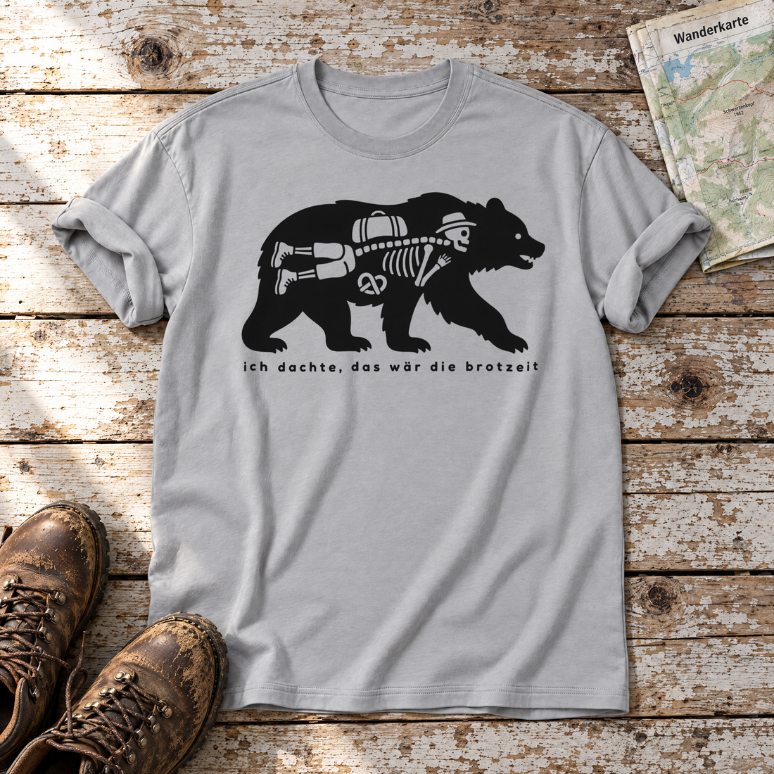 Das wär die Brotzeit – T-Shirt Unisex in Hellgrau, flach liegend auf alten Holzbrettern mit Wanderschuhen und Wanderkarte.