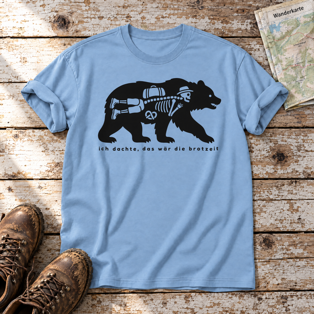 Das wär die Brotzeit – T-Shirt Unisex in Himmelblau, flach liegend auf alten Holzbrettern mit Wanderschuhen und Wanderkarte.