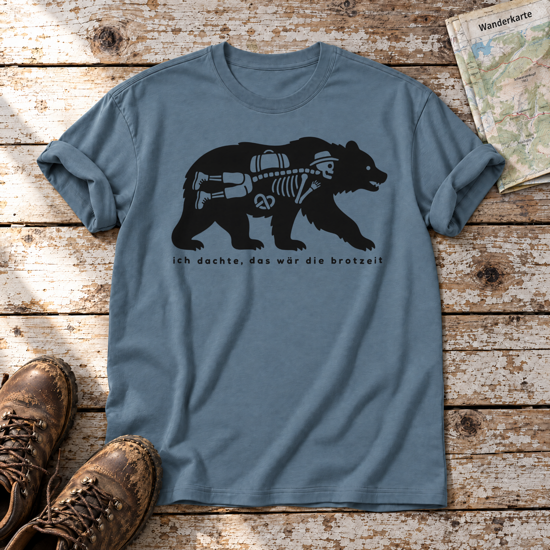 Das wär die Brotzeit – T-Shirt Unisex in Steinblau, flach liegend auf alten Holzbrettern mit Wanderschuhen und Wanderkarte.