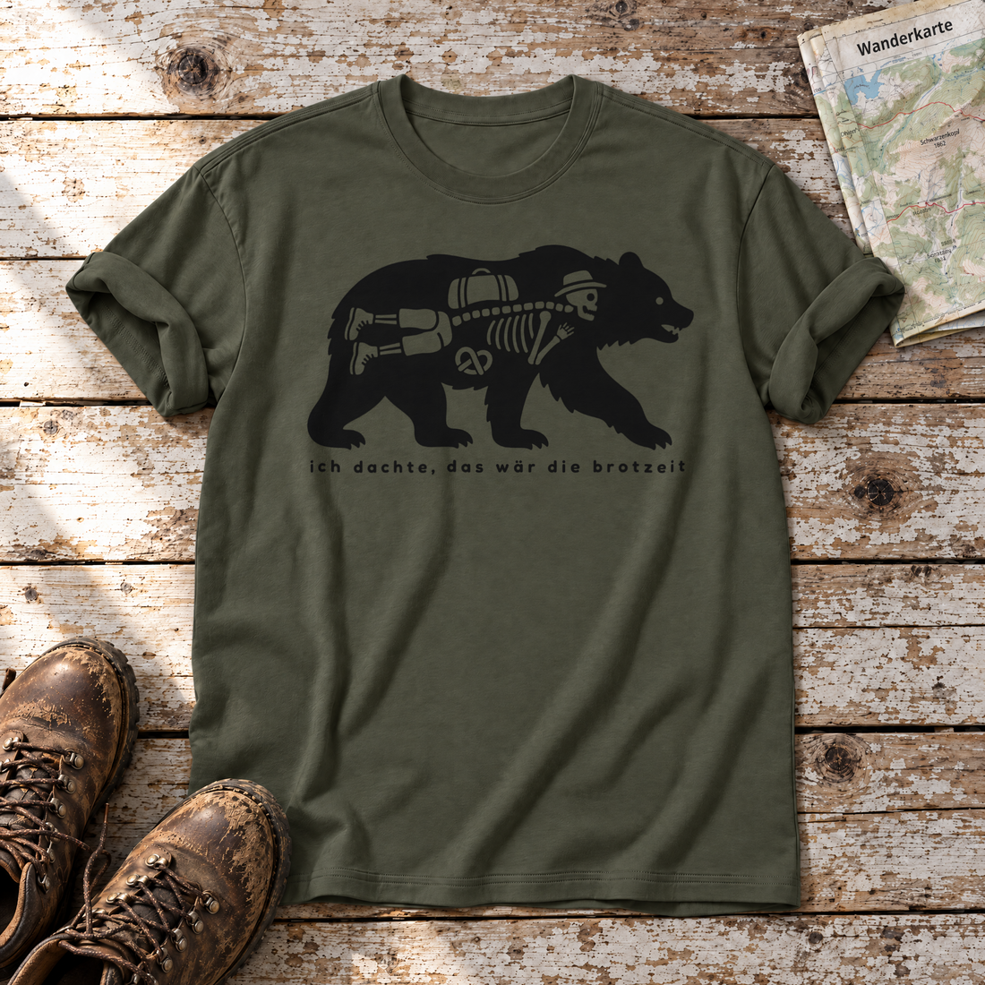 Das wär die Brotzeit – T-Shirt Unisex in Oliv, flach liegend auf alten Holzbrettern mit Wanderschuhen und Wanderkarte.