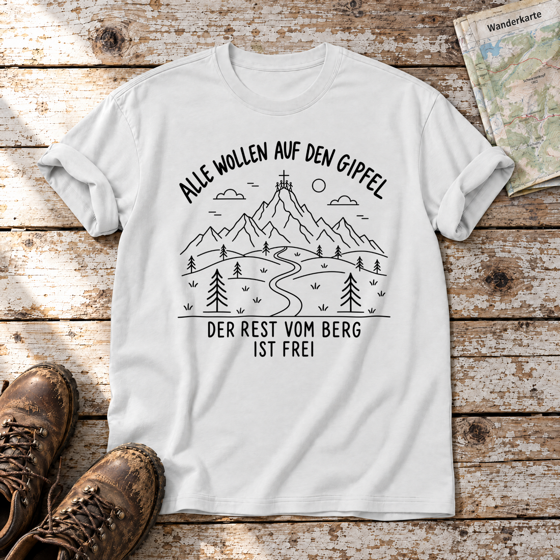 Der Rest vom Berg ist frei – T-Shirt Unisex in Weiß, flach liegend auf alten Holzbrettern mit Wanderschuhen und Wanderkarte.