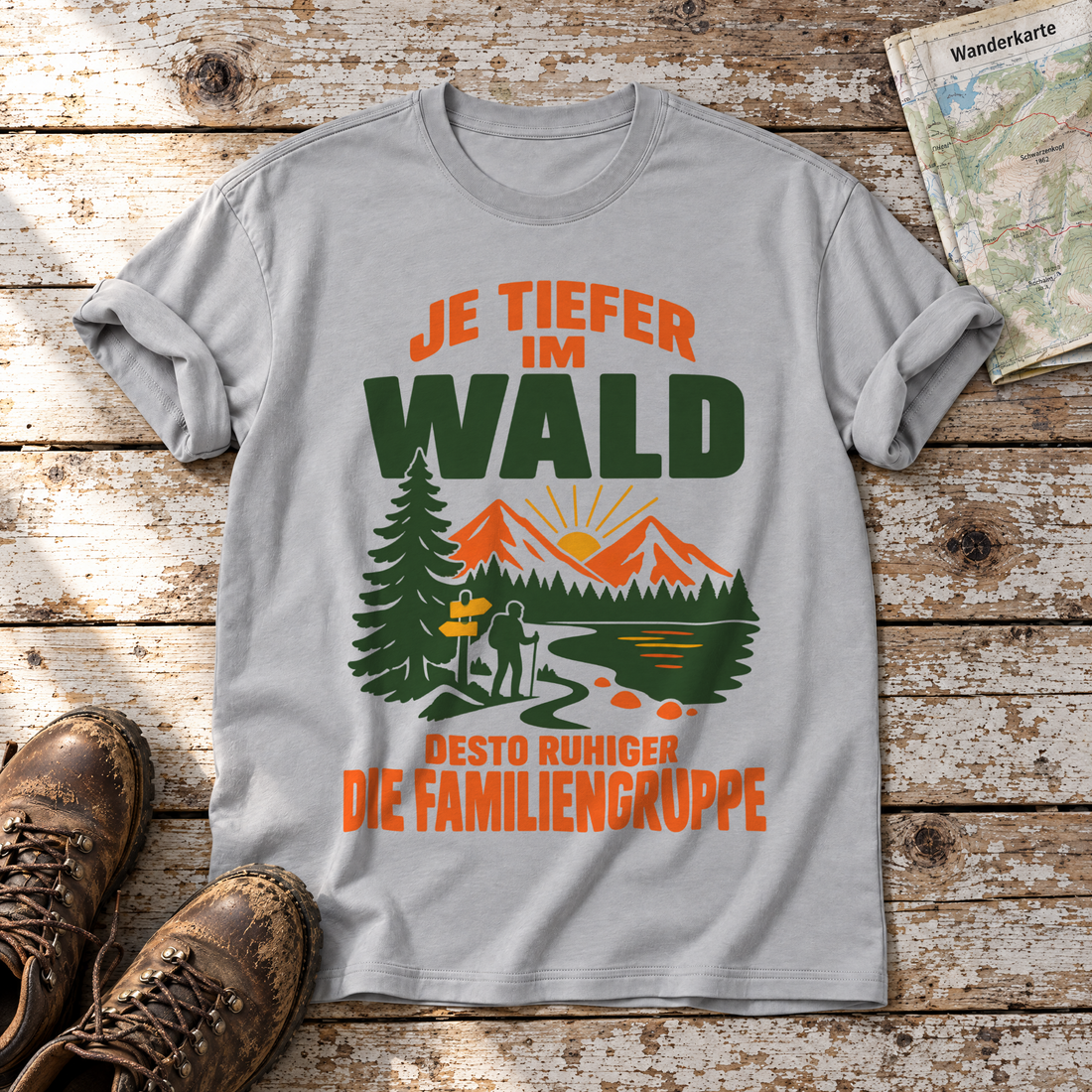 Desto ruhiger die Familiengruppe – T-Shirt Unisex in Hellgrau, flach liegend auf alten Holzbrettern mit Wanderschuhen und Wanderkarte.