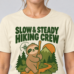 Nahaufnahme des Drucks: Slow & Steady Hiking Crew – T-Shirt Unisex in Natur, von einer Frau getragen