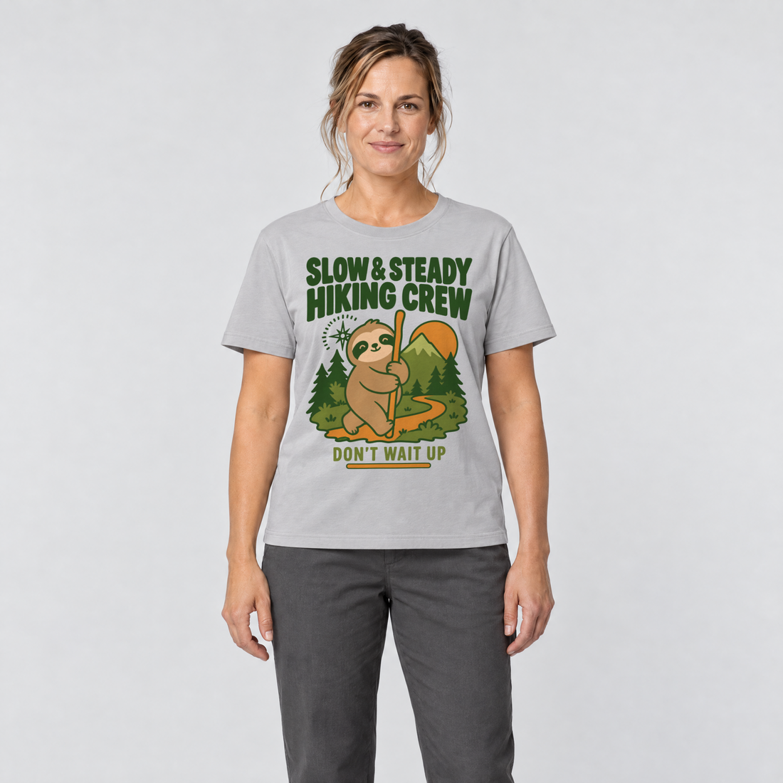 Frau trägt Slow & Steady Hiking Crew – T-Shirt Unisex in Hellgrau, Ansicht von vorn
