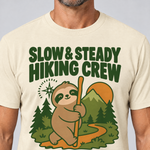 Nahaufnahme des Drucks: Slow & Steady Hiking Crew – T-Shirt Unisex in Natur, von einem Mann getragen