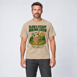 Mann trägt Slow & Steady Hiking Crew – T-Shirt Unisex in Sand, Ansicht von vorn