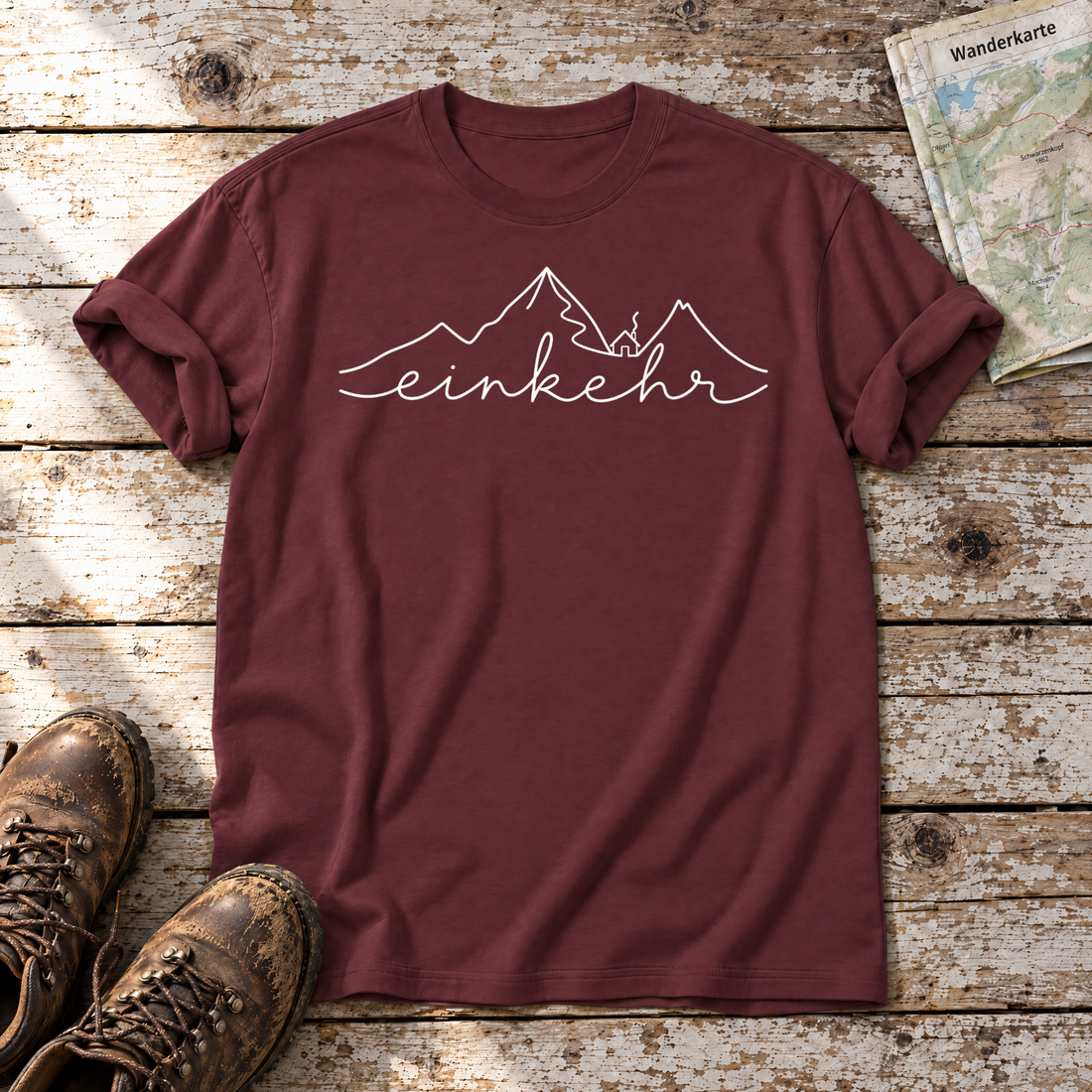 Einkehr – T-Shirt Unisex in Bordeaux, flach liegend auf alten Holzbrettern mit Wanderschuhen und Wanderkarte.