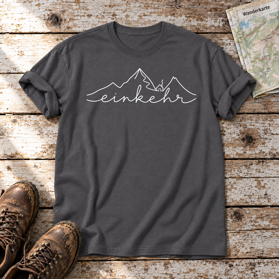 Einkehr – T-Shirt Unisex in Dunkelgrau, flach liegend auf alten Holzbrettern mit Wanderschuhen und Wanderkarte.