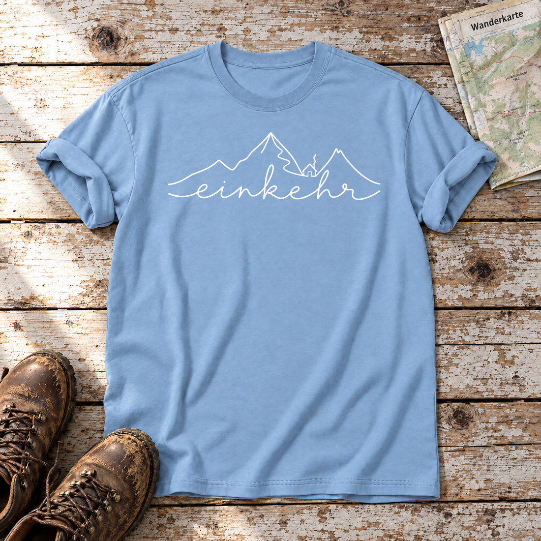 Einkehr – T-Shirt Unisex in Himmelblau, flach liegend auf alten Holzbrettern mit Wanderschuhen und Wanderkarte.