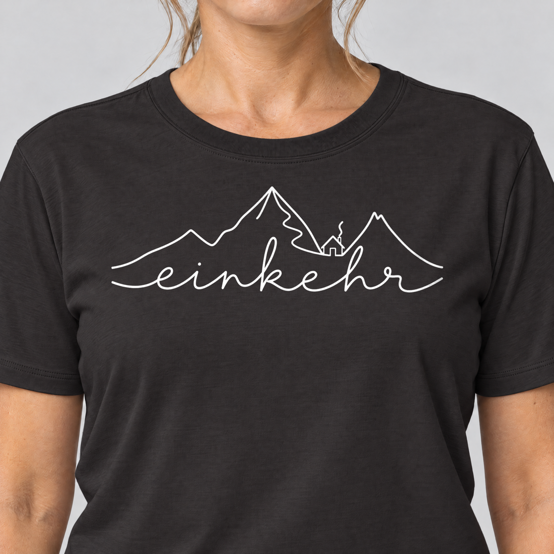 Nahaufnahme des Drucks: Einkehr – T-Shirt Unisex in Schwarz, von einer Frau getragen