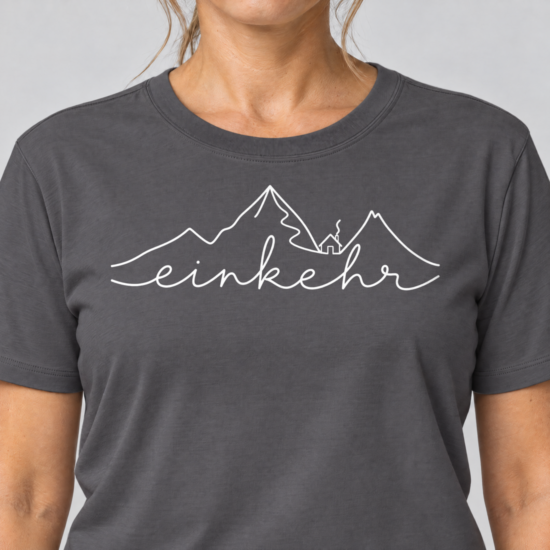 Nahaufnahme des Drucks: Einkehr – T-Shirt Unisex in Dunkelgrau, von einer Frau getragen