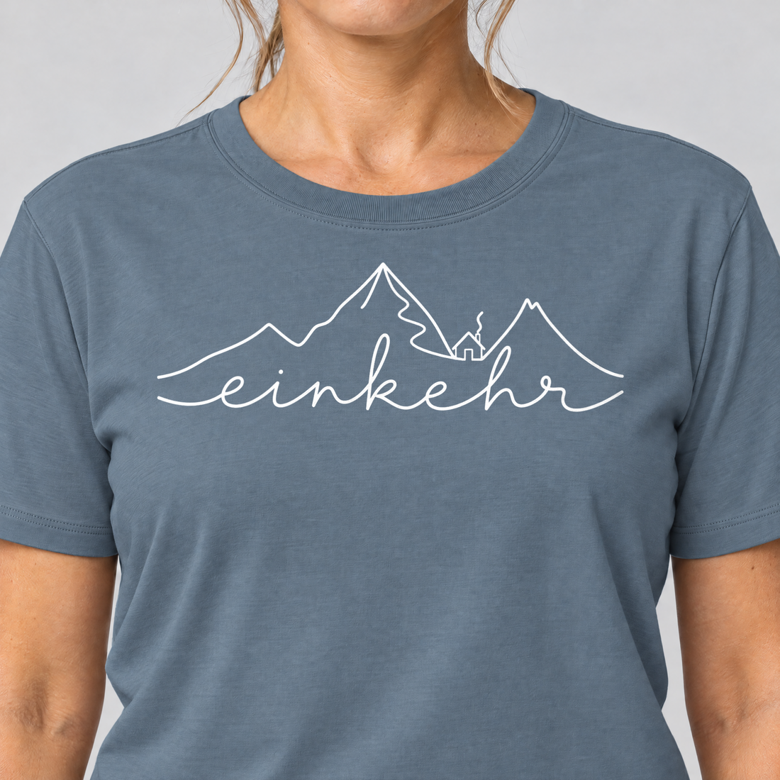 Nahaufnahme des Drucks: Einkehr – T-Shirt Unisex in Steinblau, von einer Frau getragen