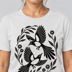 Nahaufnahme des Drucks: Elsternpaar im Scherenschnitt – T-Shirt Unisex in Weiß, von einer Frau getragen