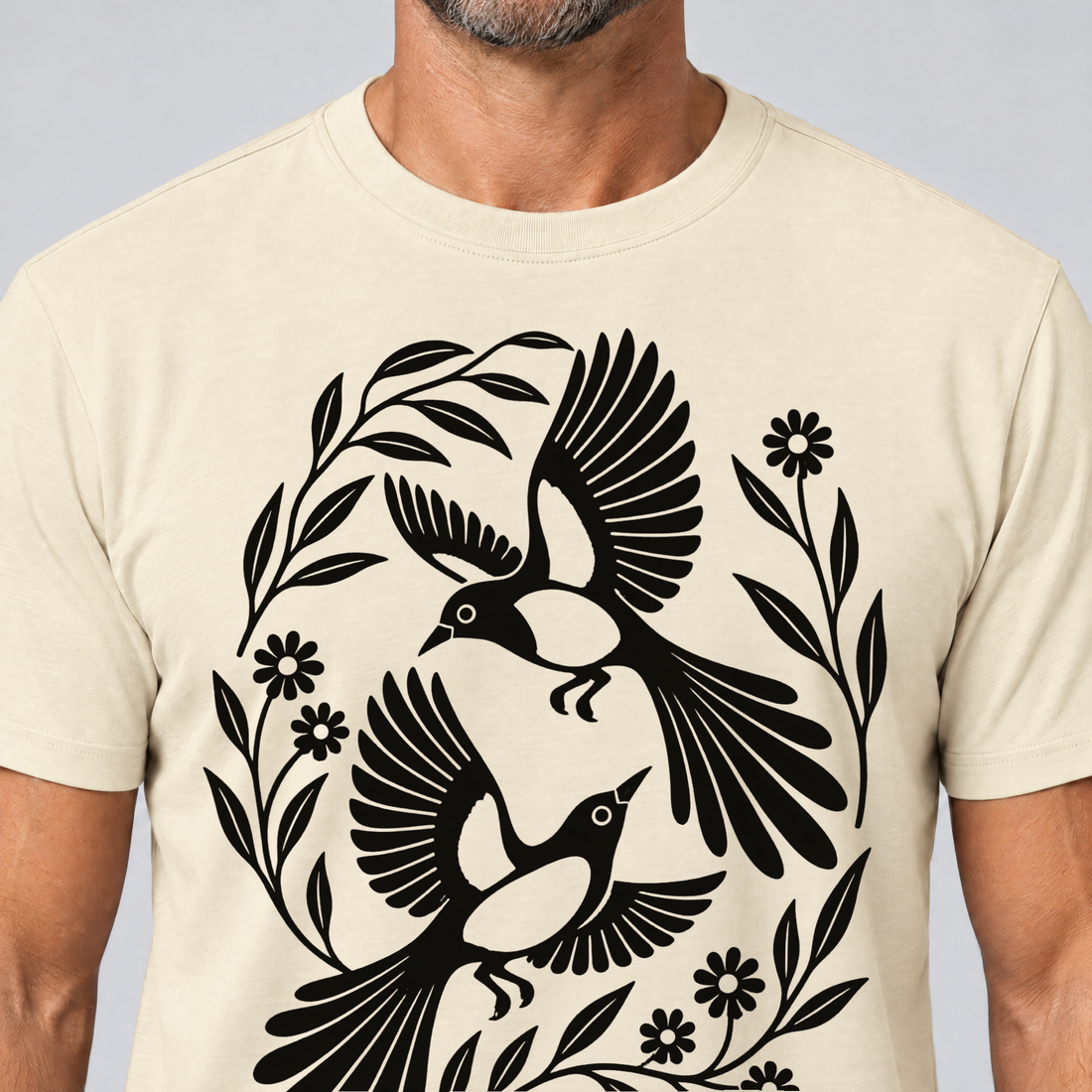 Nahaufnahme des Drucks: Elsternpaar im Scherenschnitt – T-Shirt Unisex in Natur, von einem Mann getragen
