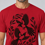 Nahaufnahme des Drucks: Elsternpaar im Scherenschnitt – T-Shirt Unisex in Rot, von einem Mann getragen