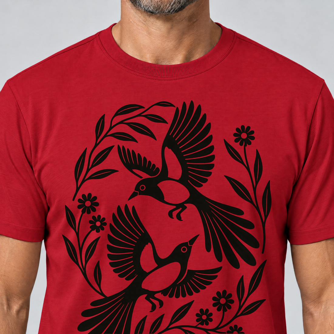 Nahaufnahme des Drucks: Elsternpaar im Scherenschnitt – T-Shirt Unisex in Rot, von einem Mann getragen
