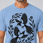 Nahaufnahme des Drucks: Elsternpaar im Scherenschnitt – T-Shirt Unisex in Himmelblau, von einem Mann getragen