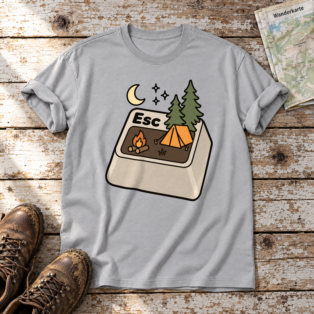 Esc – T-Shirt Unisex in Hellgrau, flach liegend auf alten Holzbrettern mit Wanderschuhen und Wanderkarte.