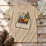 Esc – T-Shirt Unisex in Sand, flach liegend auf alten Holzbrettern mit Wanderschuhen und Wanderkarte.