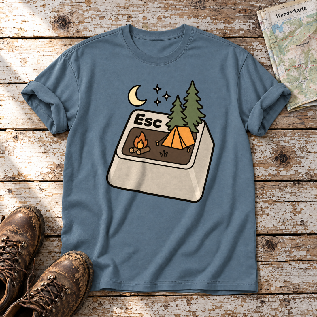 Esc – T-Shirt Unisex in Steinblau, flach liegend auf alten Holzbrettern mit Wanderschuhen und Wanderkarte.