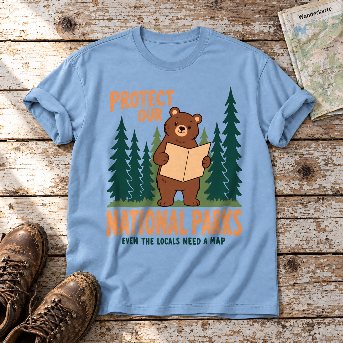 Even the Locals Need a Map – T-Shirt Unisex in Himmelblau, flach liegend auf alten Holzbrettern mit Wanderschuhen und Wanderkarte.