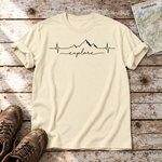 Explore Herzschlag – T-Shirt Unisex in Natur, flach liegend auf alten Holzbrettern mit Wanderschuhen und Wanderkarte.
