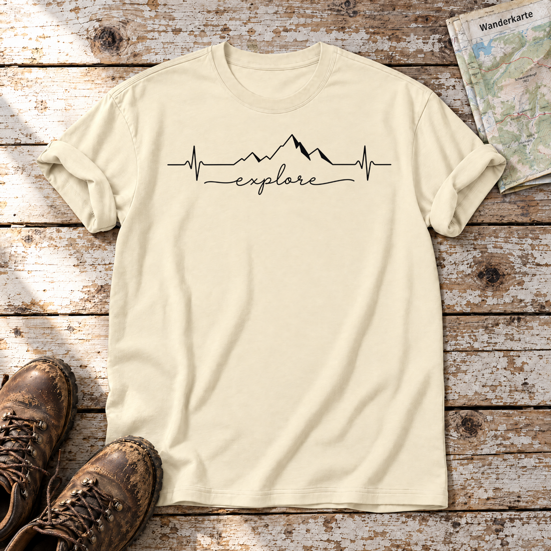 Explore Herzschlag – T-Shirt Unisex in Natur, flach liegend auf alten Holzbrettern mit Wanderschuhen und Wanderkarte.