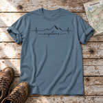 Explore Herzschlag – T-Shirt Unisex in Steinblau, flach liegend auf alten Holzbrettern mit Wanderschuhen und Wanderkarte.