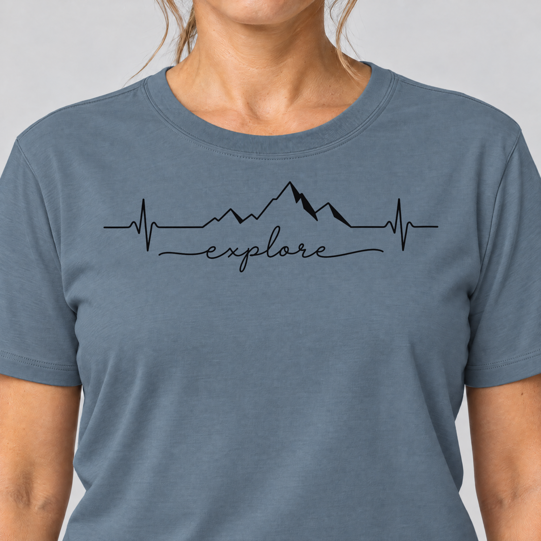 Nahaufnahme des Drucks: Explore Herzschlag – T-Shirt Unisex in Steinblau, von einer Frau getragen