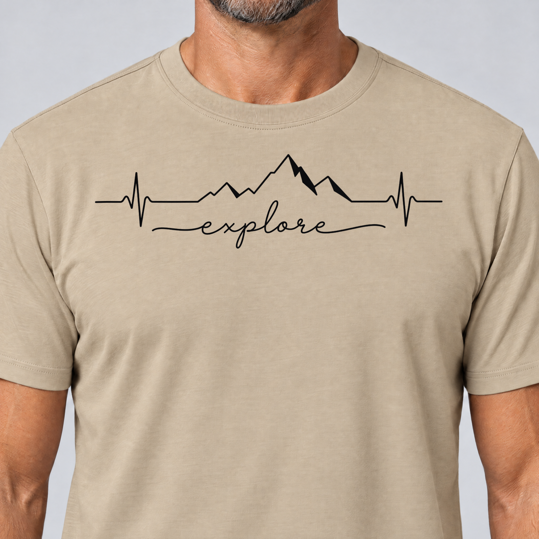 Nahaufnahme des Drucks: Explore Herzschlag – T-Shirt Unisex in Sand, von einem Mann getragen