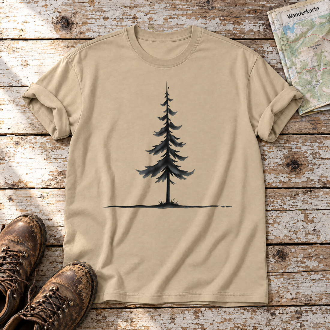 Fichte am Horizont – T-Shirt Unisex in Sand, flach liegend auf alten Holzbrettern mit Wanderschuhen und Wanderkarte.