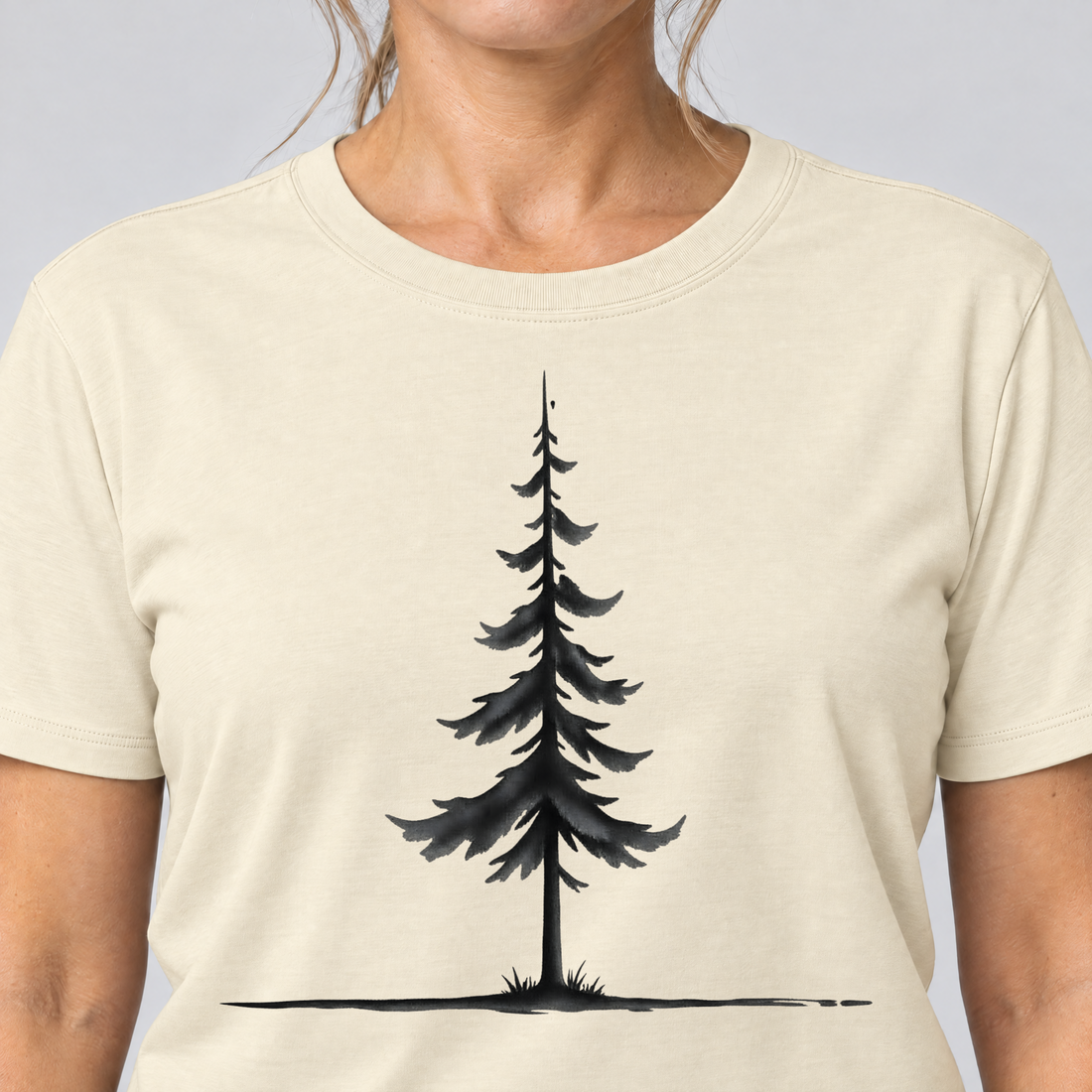 Nahaufnahme des Drucks: Fichte am Horizont – T-Shirt Unisex in Natur, von einer Frau getragen