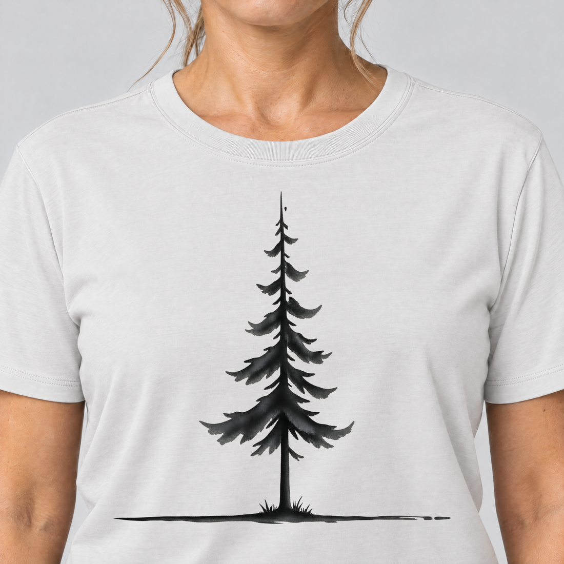 Nahaufnahme des Drucks: Fichte am Horizont – T-Shirt Unisex in Weiß, von einer Frau getragen