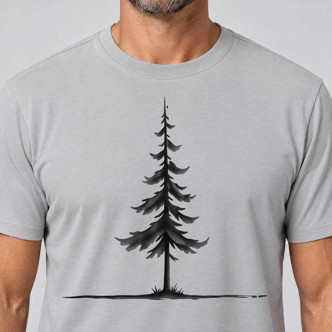 Nahaufnahme des Drucks: Fichte am Horizont – T-Shirt Unisex in Hellgrau, von einem Mann getragen