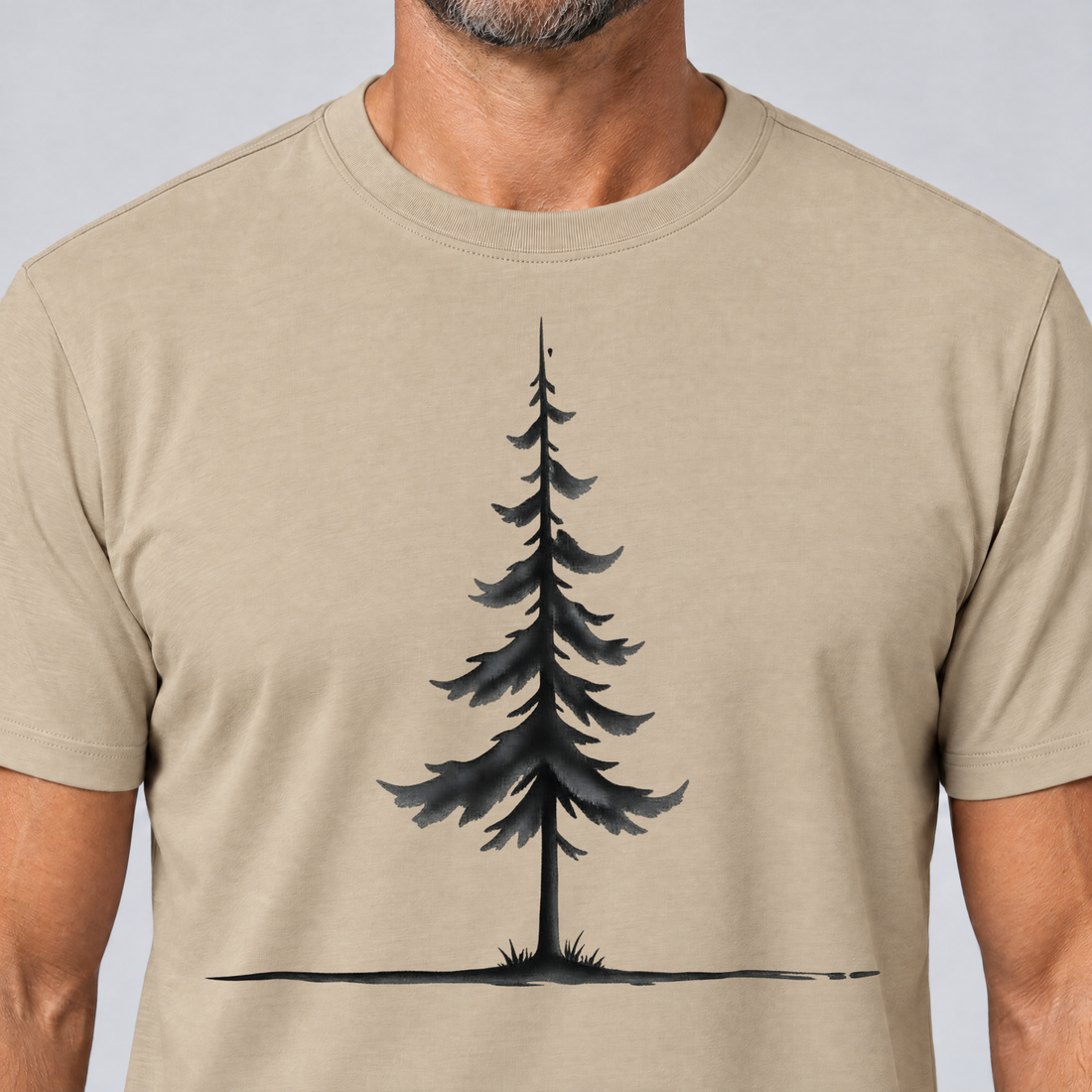 Nahaufnahme des Drucks: Fichte am Horizont – T-Shirt Unisex in Sand, von einem Mann getragen